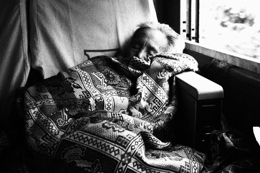 An old lady sleeping on the train